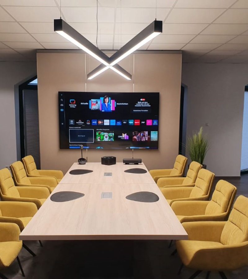 Moderne LED Leuchte nach Maß über großem Konferenztisch im Konferenzraum